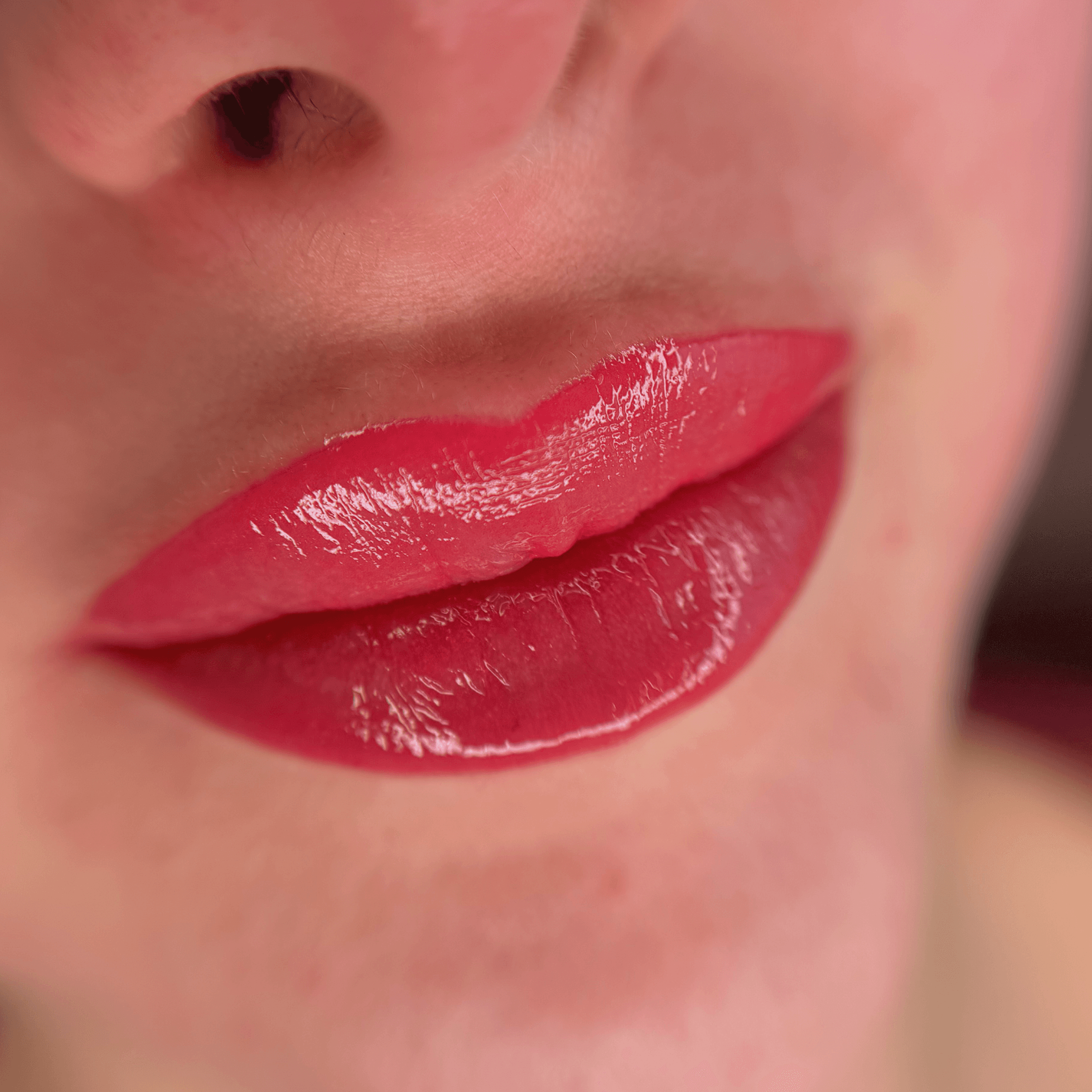 Résultat d'un tatouage des lèvres permanent Candy Lips avec une pigmentation rose intense et un fini effet gloss brillant réalisé par l'experte Habiba Med.